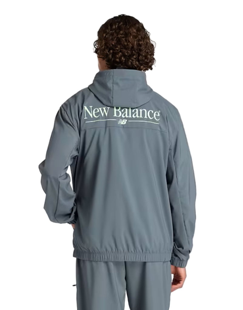 Person wearing a gray New Balance tracksuit on a white background