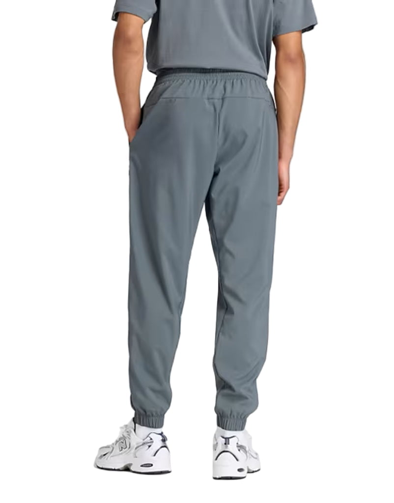 Person wearing gray jogger pants and white sneakers on a white background