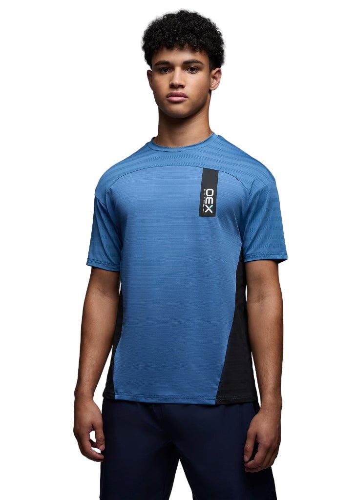 Person wearing a blue athletic shirt with a brand logo on a gray background