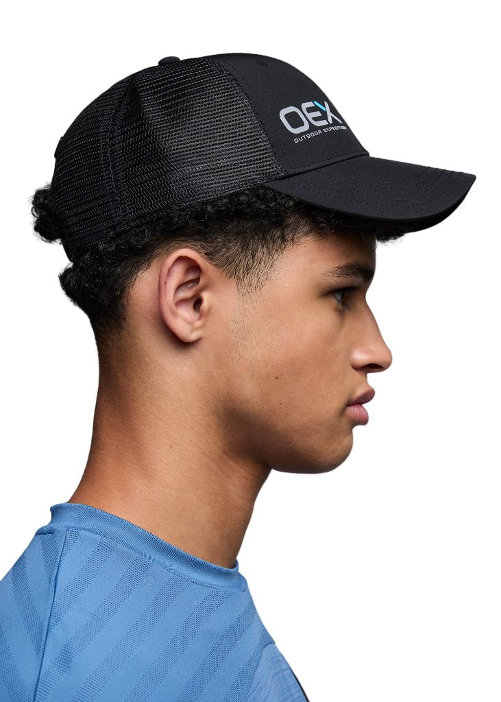 Person wearing a black cap with a brand logo on a white background