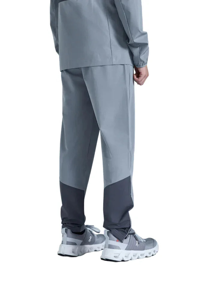 Person wearing a gray outfit with pants and shoes on a white background