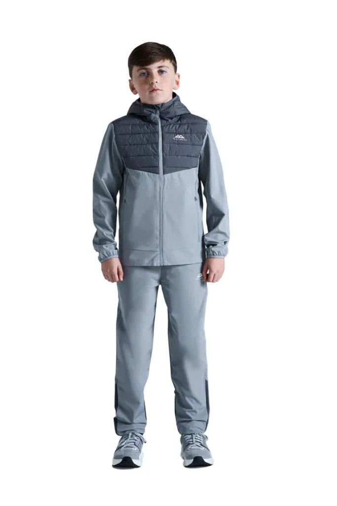 Child wearing a gray and navy tracksuit on a white background
