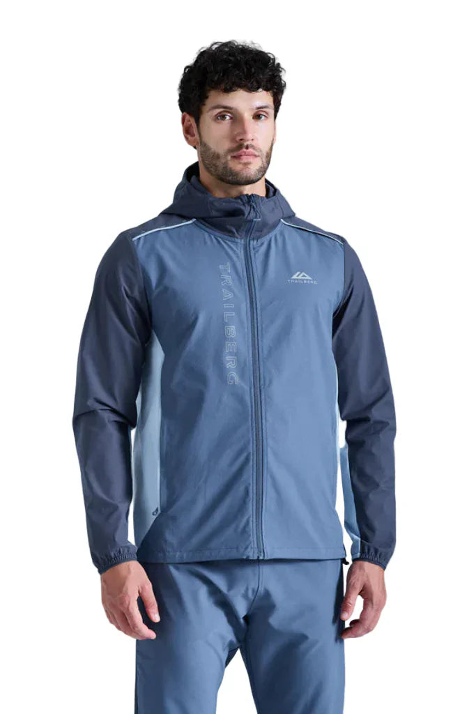 Man wearing a blue raincoat with a brand logo on a gray background