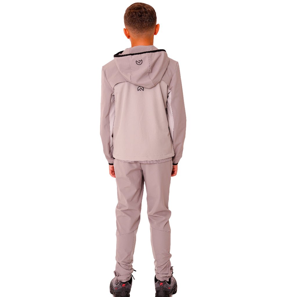 Person wearing a light gray tracksuit on a white background