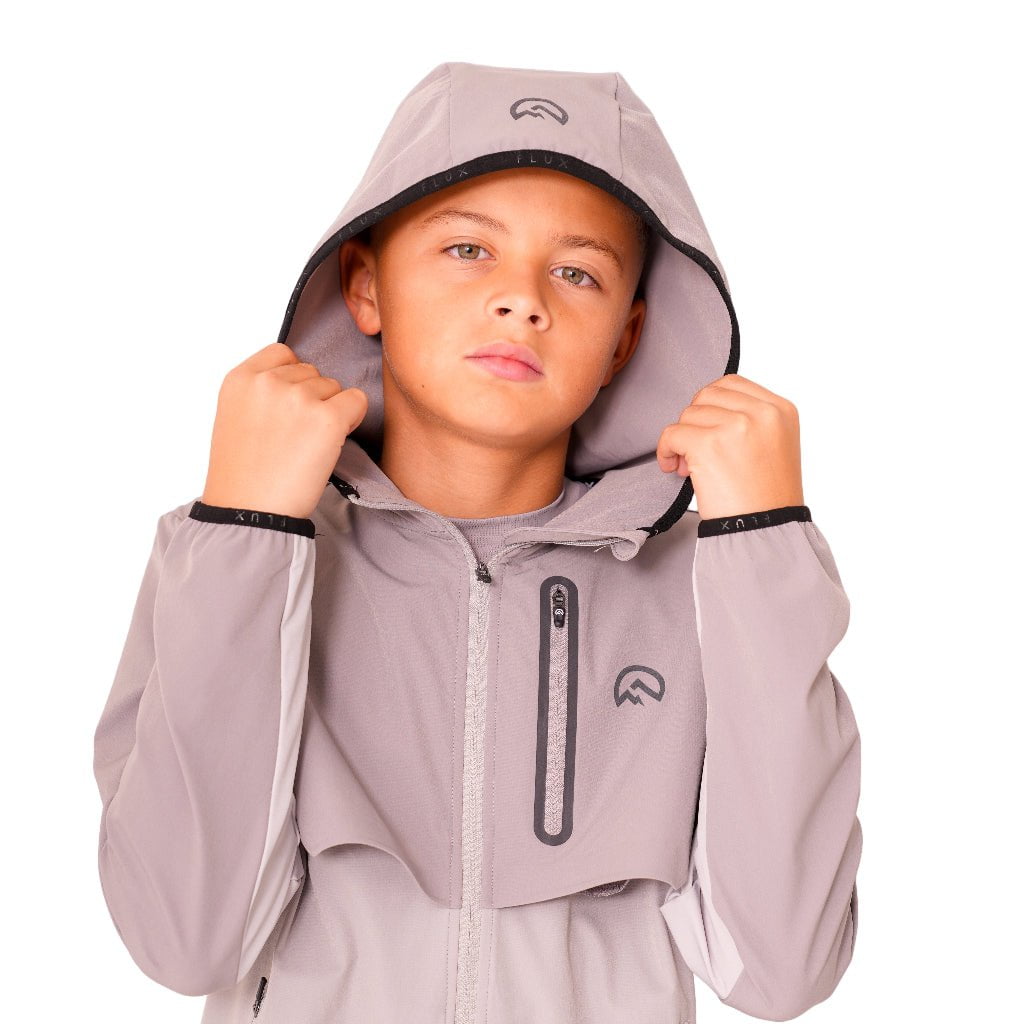 Child wearing a gray hooded jacket with a brand logo on a white background