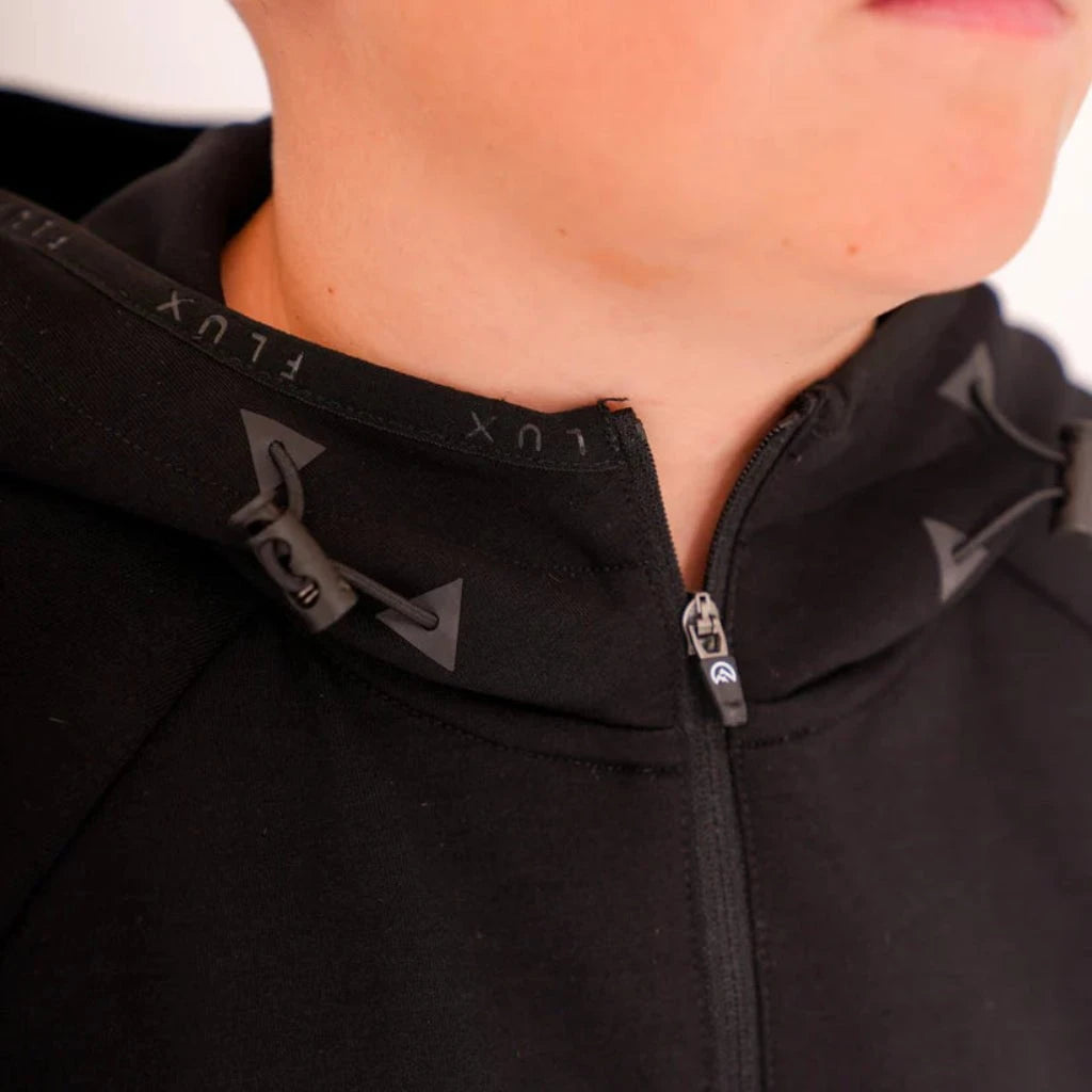 Close-up of a black jacket with a zipper and brand logo on a blurred background