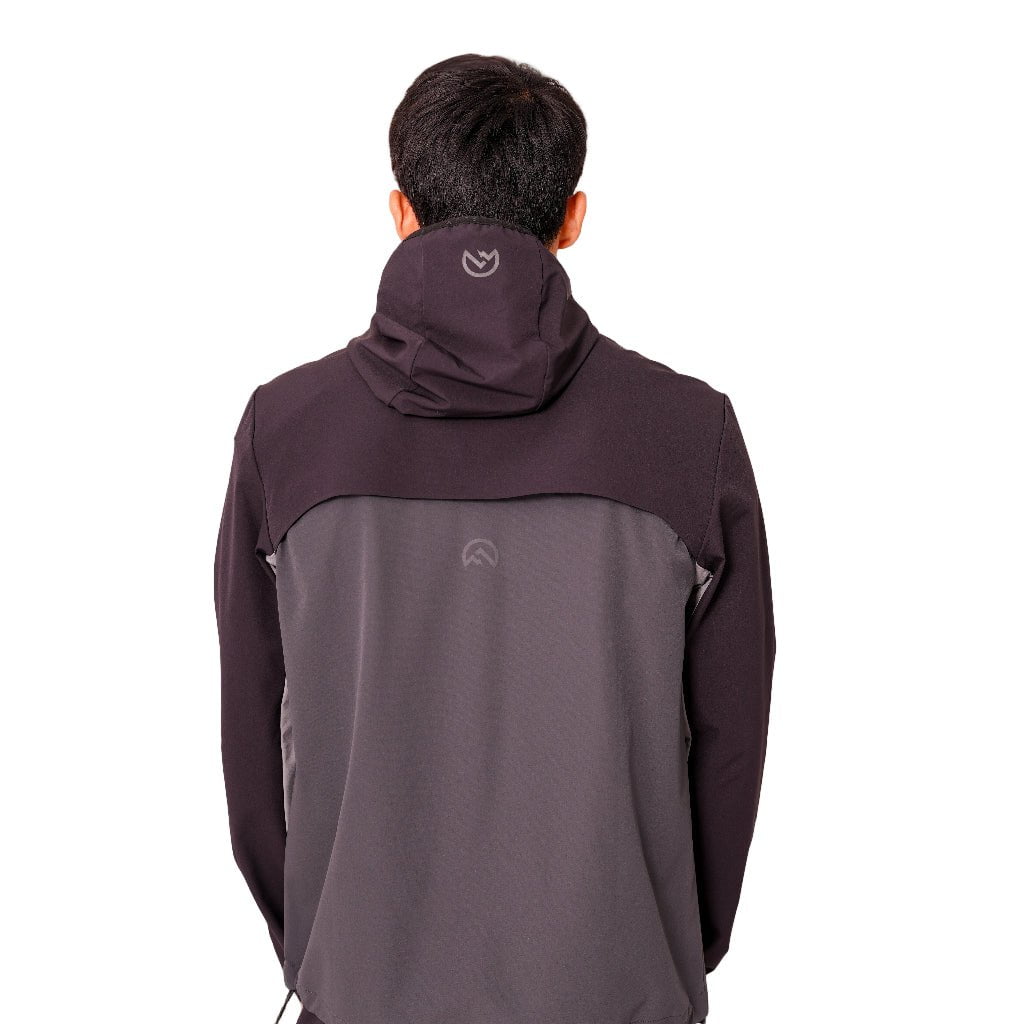 Person wearing a two-tone jacket with a visible brand logo on a white background